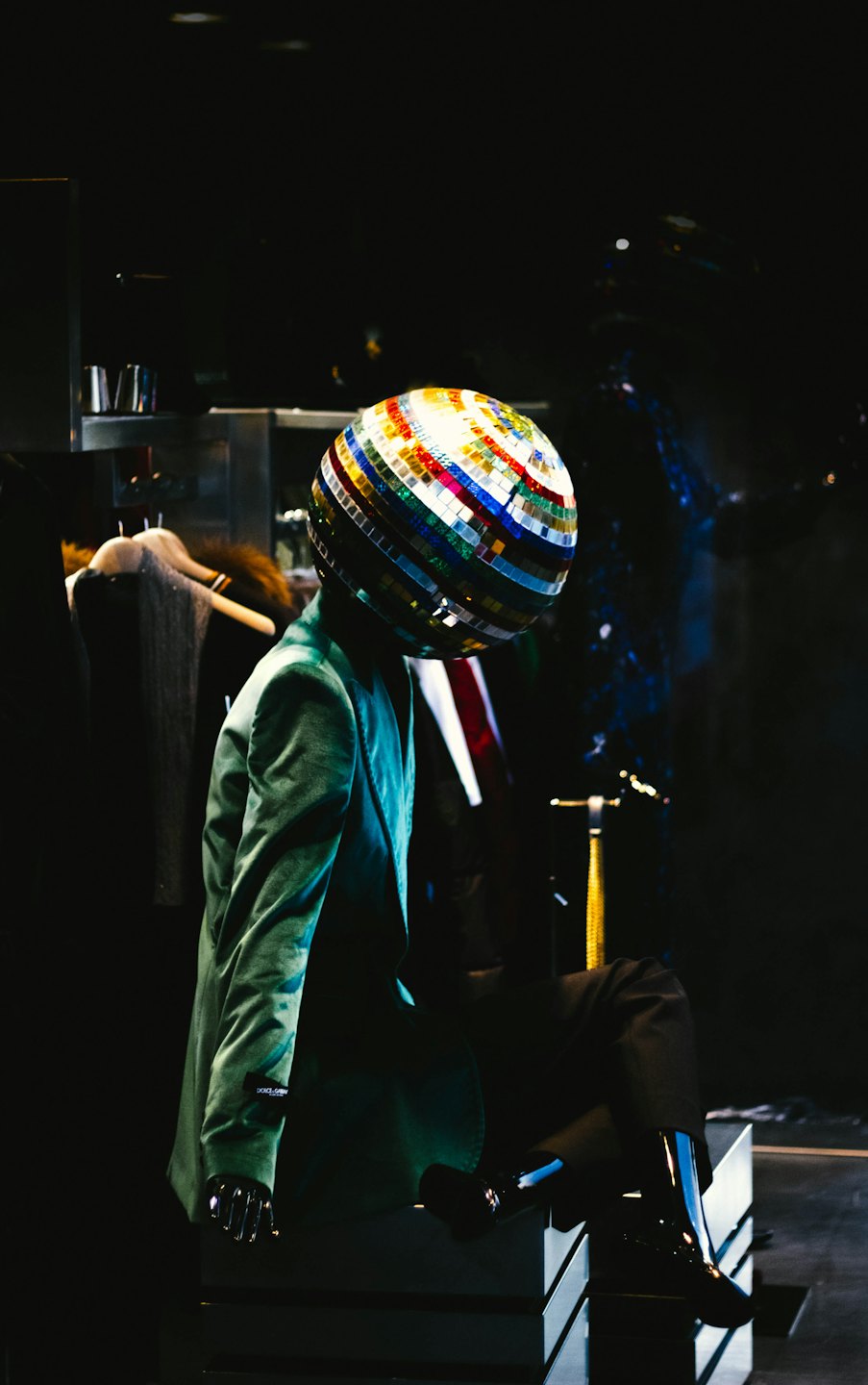 Mannequin with disco ball head wearing green velvet blazer.